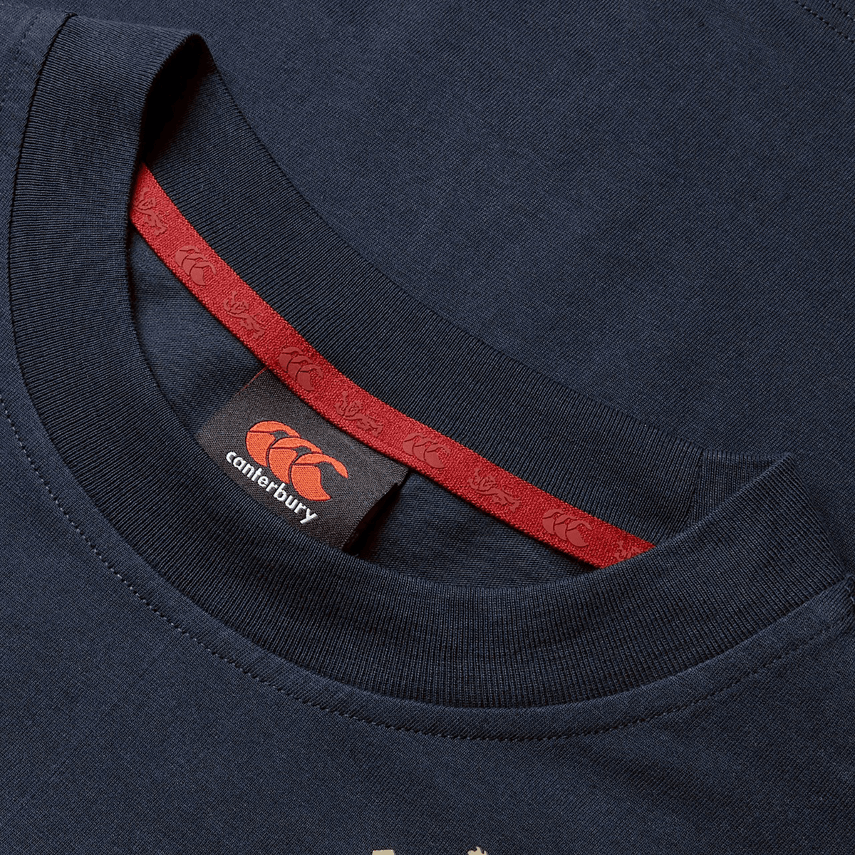 Close-up of the Women's British &amp; Irish Lions 25 Cotton Jersey Tee by Canterbury in navy blue, crafted from organic cotton. It features a striking red neckline detail and a Canterbury logo on the inner label—an essential for any British &amp; Irish Lions rugby supporter.