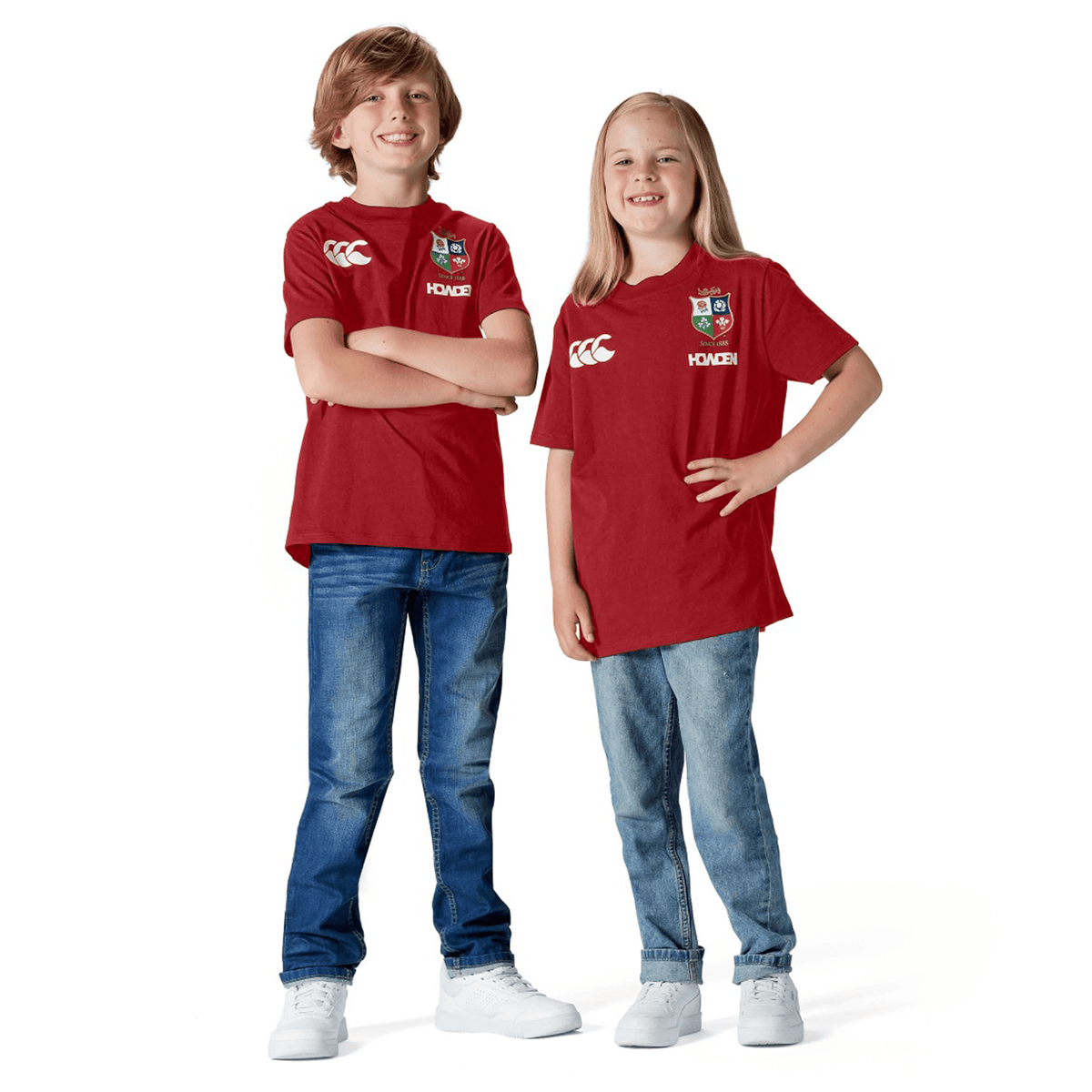 Two children in Youth British &amp; Irish Lions 2025 Cotton Jersey Tees by Canterbury smile in a studio, proudly showing their support as young British &amp; Irish Lions fans.