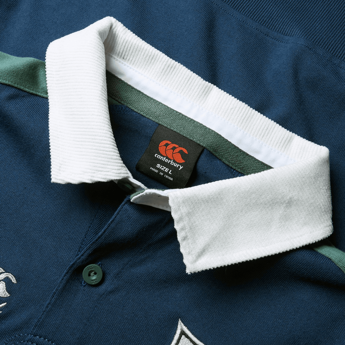 The British &amp; Irish Lions 2025 Heritage Jersey by Canterbury is a blue rugby shirt with a white collar and green accents, complete with a buttoned neckline and an embroidered logo. This jersey honors the classic style of the British &amp; Irish Lions, merging timeless tradition with a modern twist.