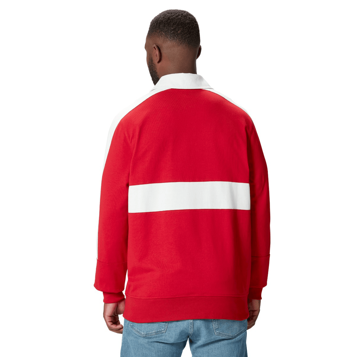 A person wearing a red and white British &amp; Irish Lions 2025 Heritage Jersey by Canterbury and blue jeans stands facing away.