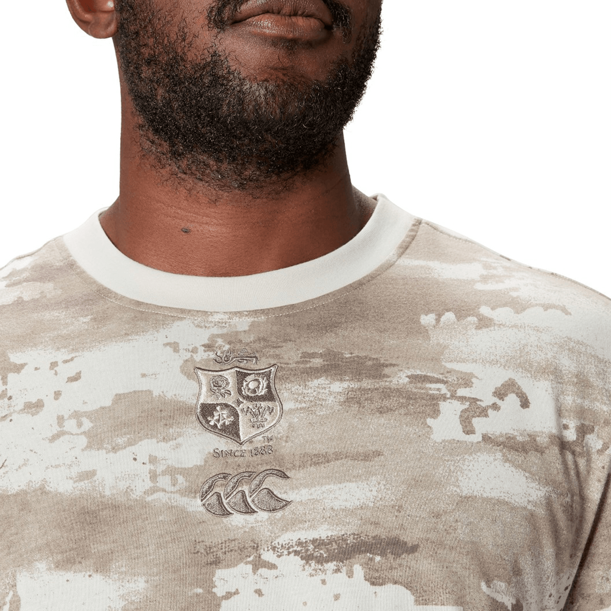 A man in a British &amp; Irish Lions 2025 Camo Tee by Canterbury, featuring a crest and logo on the chest.