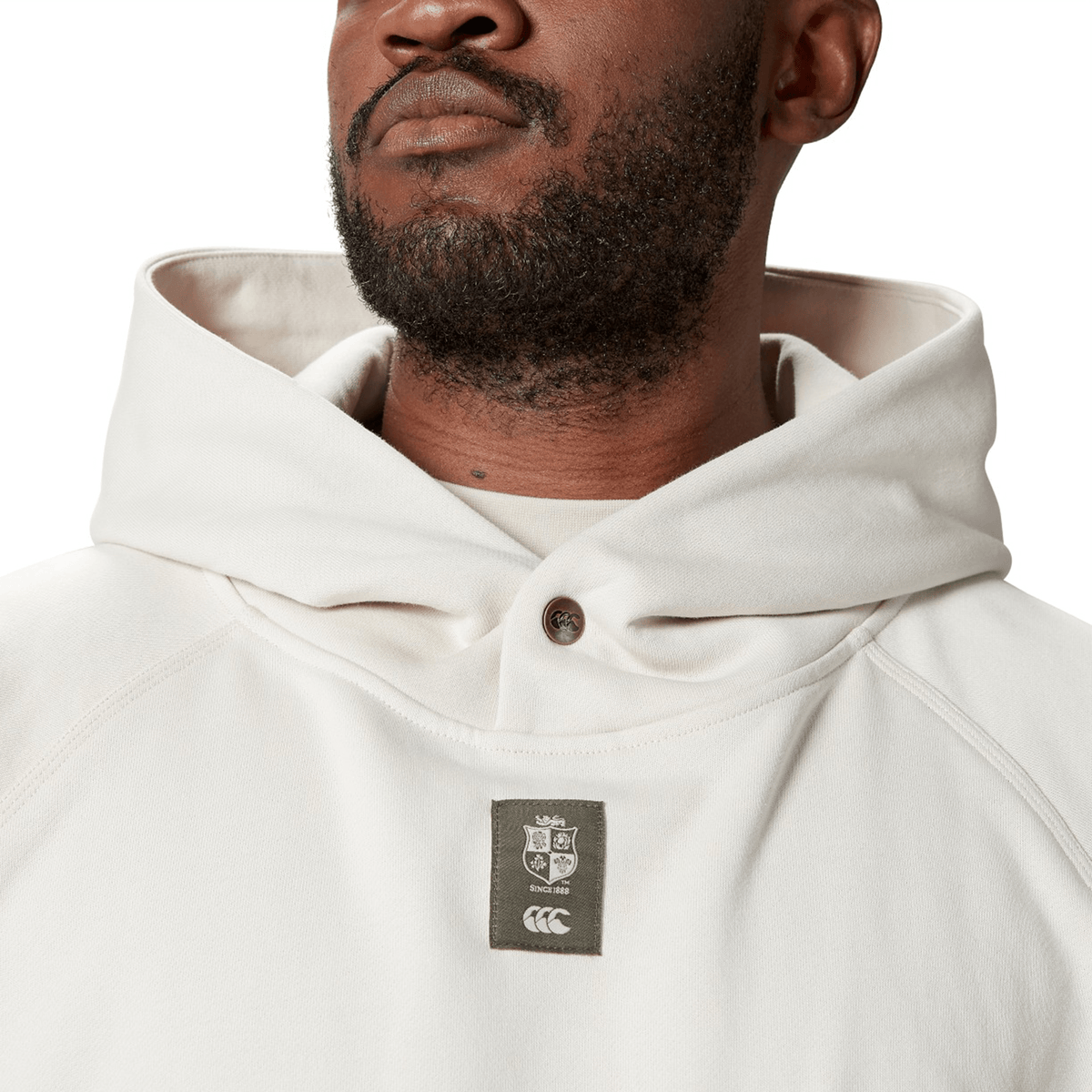 Man wearing a British &amp; Irish Lions 2025 Outback Fleece Hoodie by Canterbury featuring a logo patch on the front.