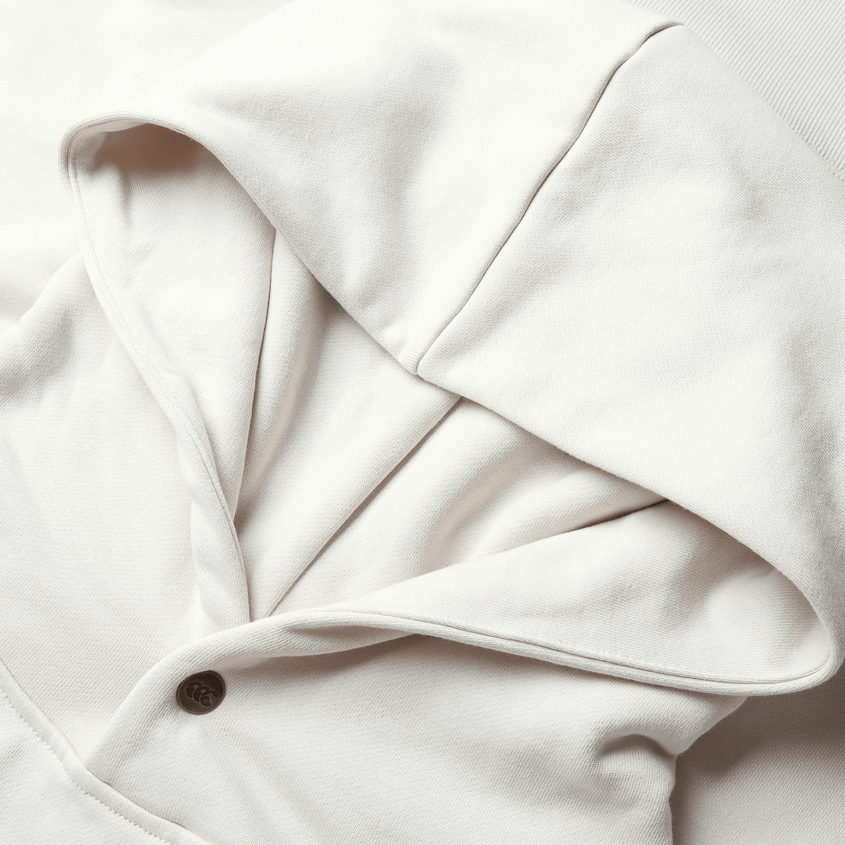 A close-up of the British &amp; Irish Lions 2025 Outback Fleece Hoodie by Canterbury reveals its textured fabric detail and buttoned collar, offering a glimpse into the hood's cozy interior, embodying the spirit of the British &amp; Irish Lions.