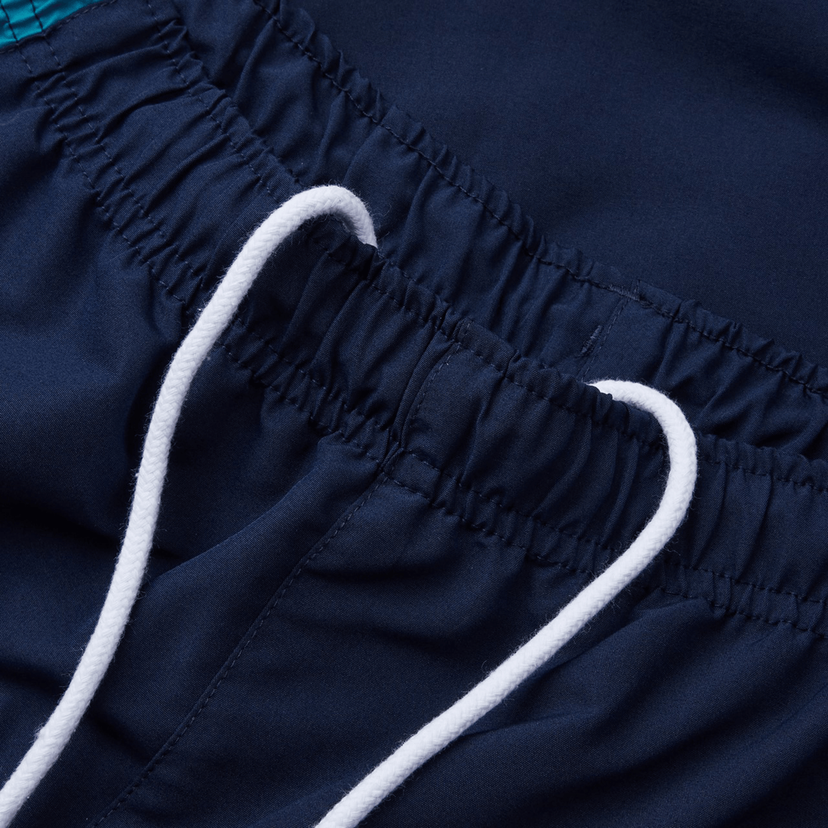 Close-up of Canterbury Harlequin Legends Trackpant in navy blue with white drawstrings, ideal for rugby enthusiasts. The elastic waistband provides comfort and style similar to the classic Canterbury look.