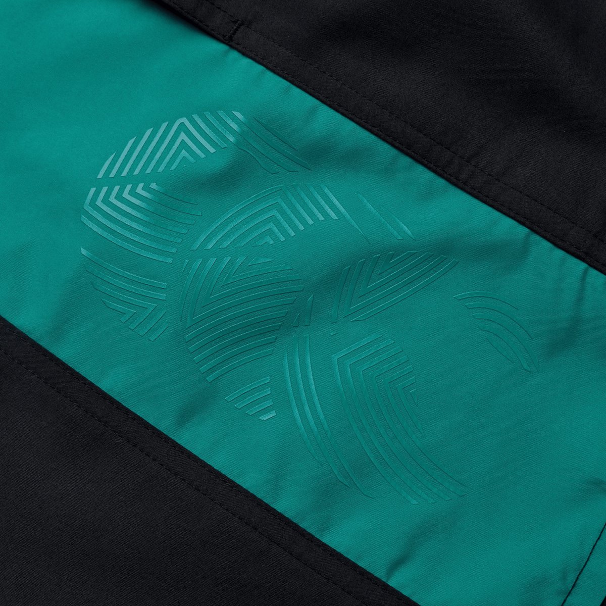 Close-up of the Canterbury Fundamental 5" Panel Tactic Short in teal and black, showcasing an embossed abstract geometric pattern with curved and straight lines. Perfect for combining style with functionality in moisture-wicking shorts.