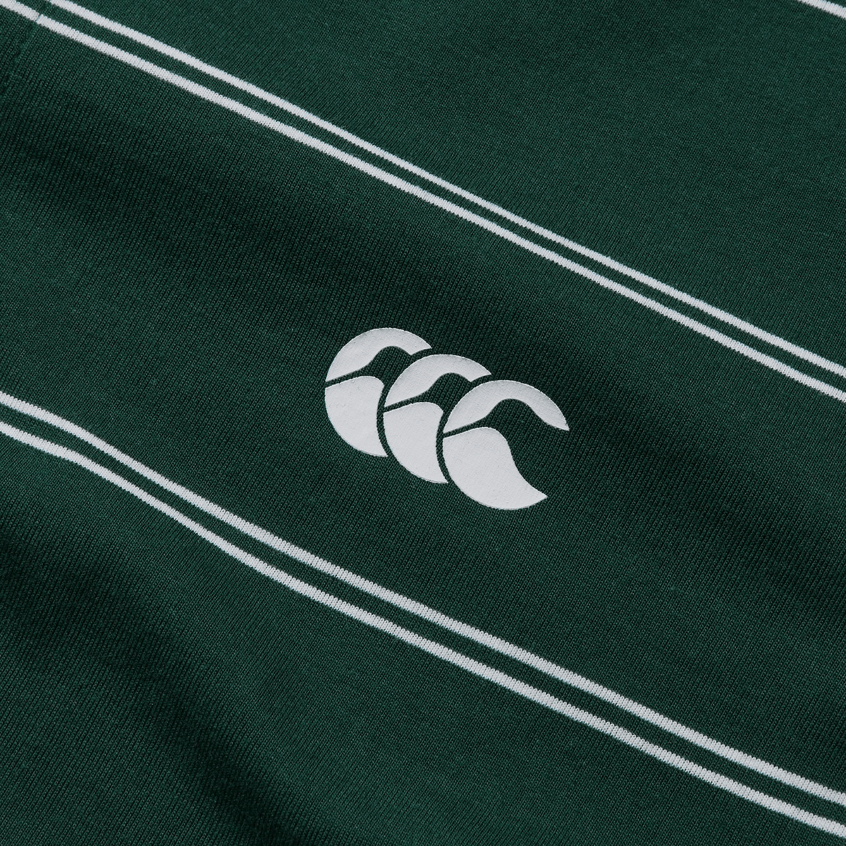Close-up of the Canterbury Fundamental Yarn-Dye Stripe Polo, showcasing its green fabric with yarn-dye stripes and a central white logo featuring three interlocking shapes.