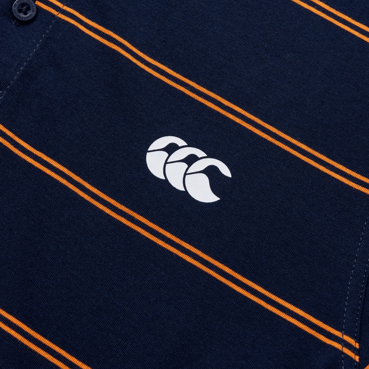 Close-up of the Canterbury Fundamental Yarn-Dye Stripe Polo in dark blue with orange stripes and a white logo featuring three overlapping shapes.