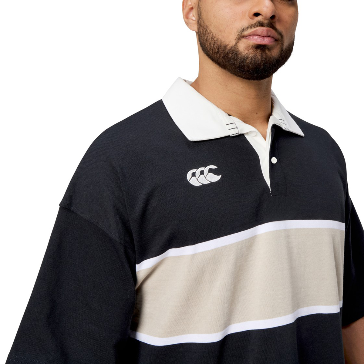 Man wearing a black and beige striped Canterbury Yarn Dye Short Sleeve Rugby Jersey with a crisp white collar.