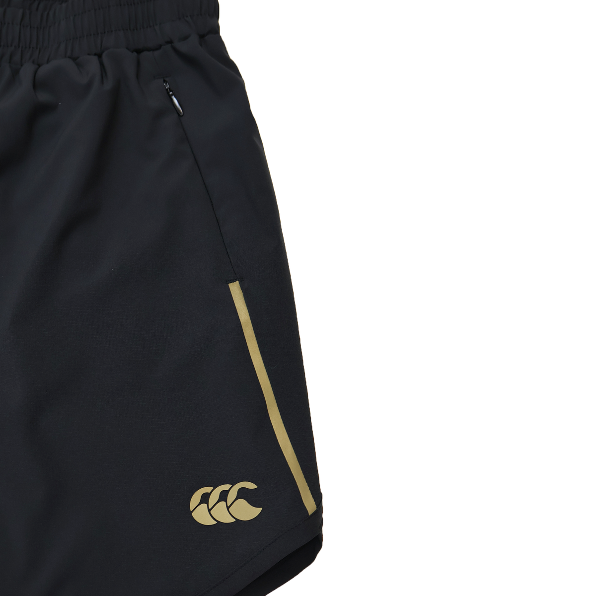 Close-up of Canterbury Women&#39;s Tempo+ 5&quot; Training Shorts in black, featuring a yellow logo and side stripe, elastic waistband, zippered pocket, and moisture-wicking fabric for comfort.