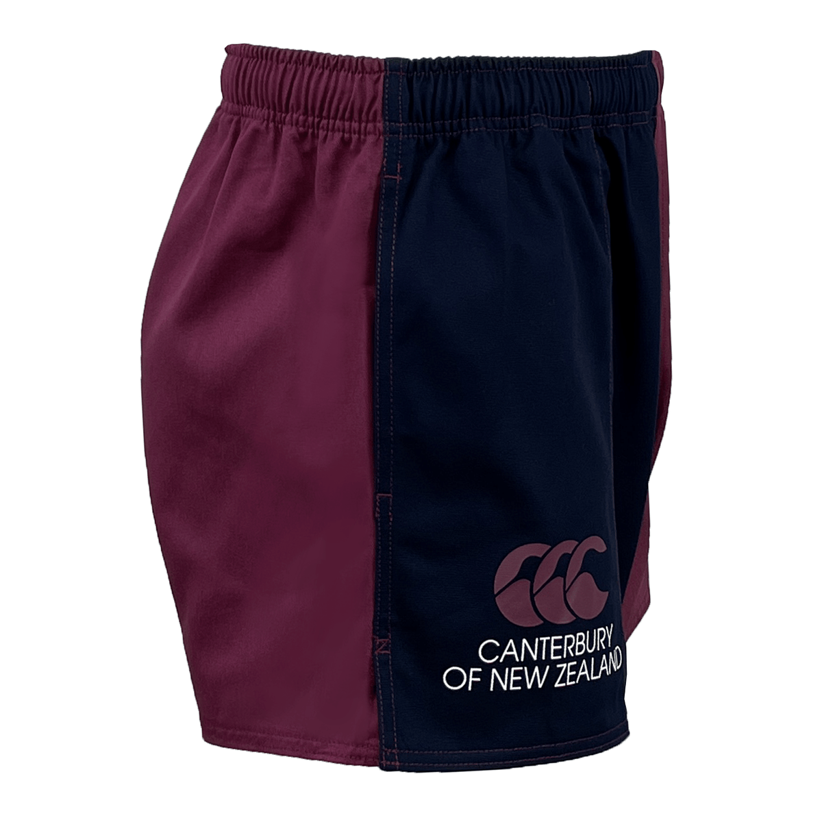 A pair of Canterbury 3" Harlequin Shorts for men features one side in maroon and the other in navy blue. The left leg proudly displays a "Canterbury of New Zealand" logo, giving these distinctive shorts a flair that's perfect for any active wardrobe.
