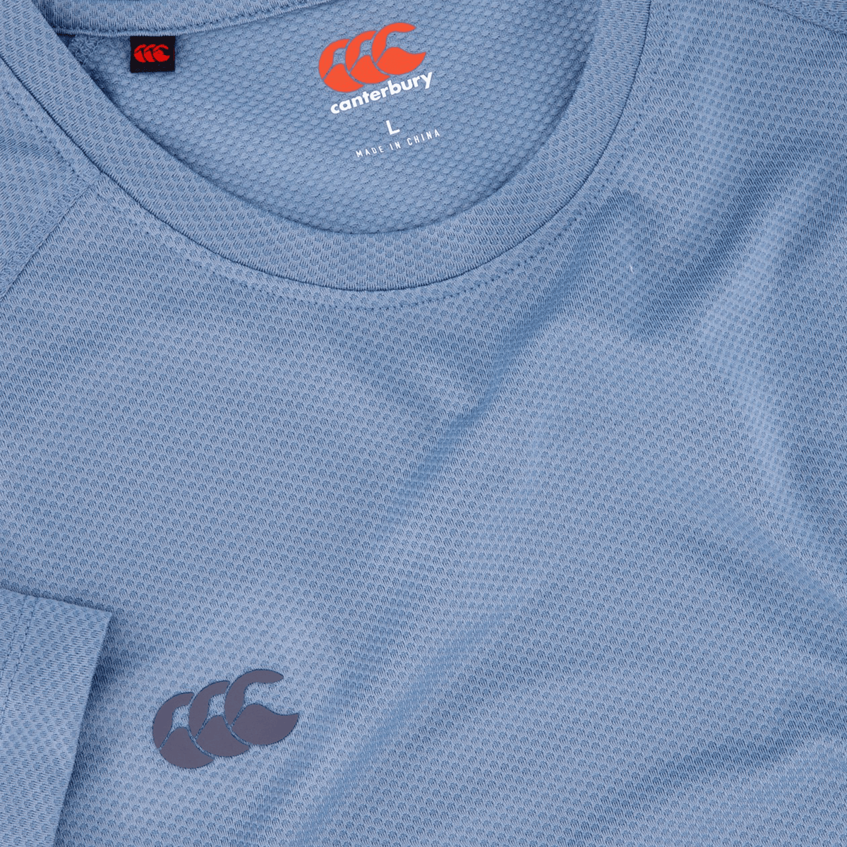 Light blue Canterbury Tempo+ Training Tee with moisture-wicking fabric, featuring the brand logo on the chest and collar.