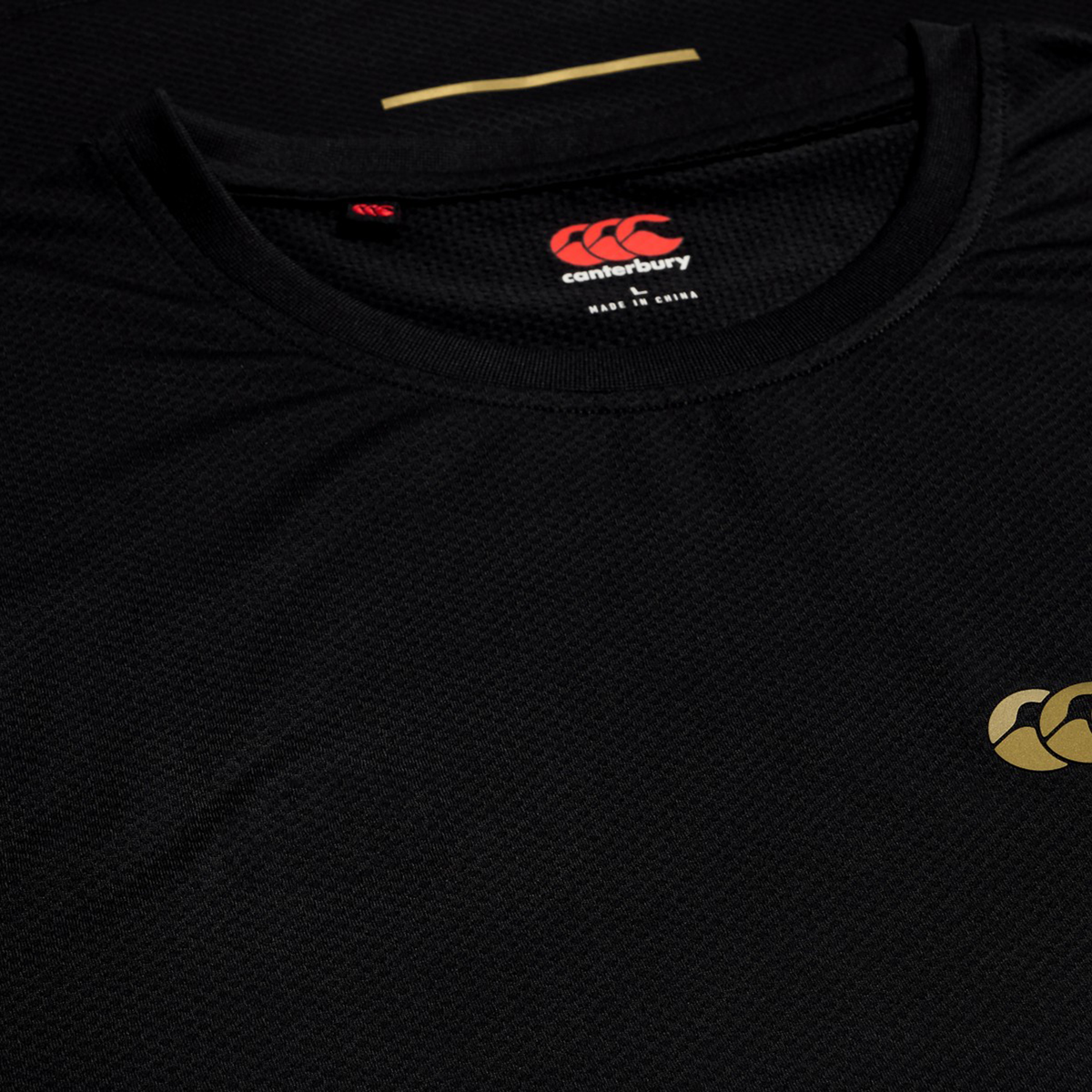Black Tempo+ Training Tank by Canterbury with an athletic fit, featuring a gold chest logo and round neckline, laid flat on a surface.