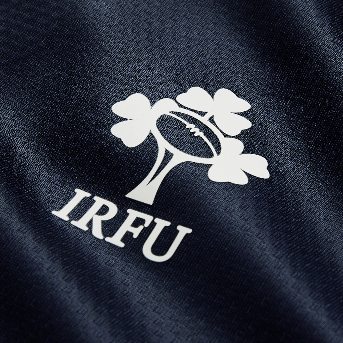 Close-up of the IRFU logo with rugby ball and shamrock on Canterbury’s Ireland 26/27 Summer Tour "Indigo" Training Test Jersey, part of the latest collection.