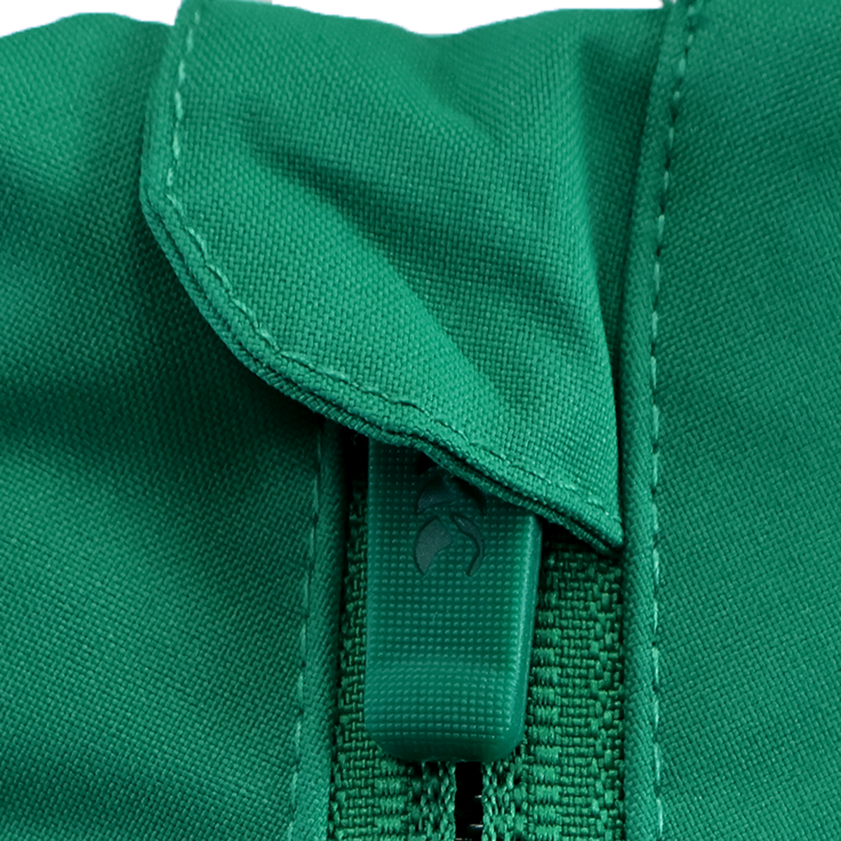 Close-up of a green zipper with fabric pull tab and visible stitching on green cloth, featured on the Ireland 25/26 Anthem Jacket by Canterbury.