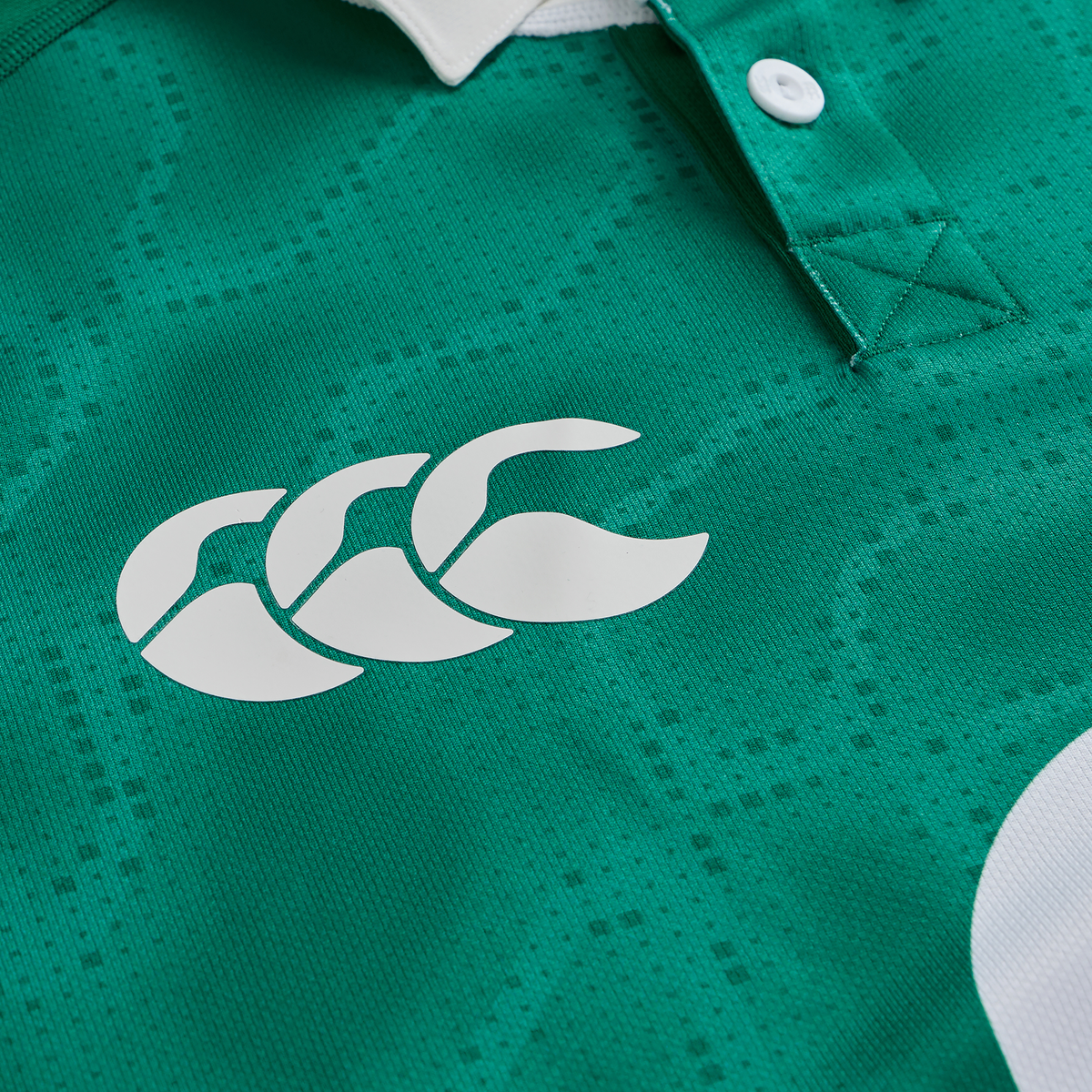 Close-up of the Ireland 25/26 Home Pro Jersey by Canterbury in green, highlighting the white Canterbury logo and a partial white buttoned collar.