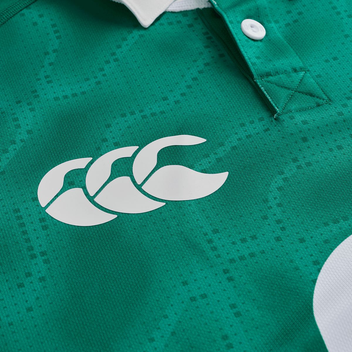 Close-up of the Ireland 25/26 Home Pro Jersey by Canterbury in green, highlighting the white Canterbury logo and a partial white buttoned collar.