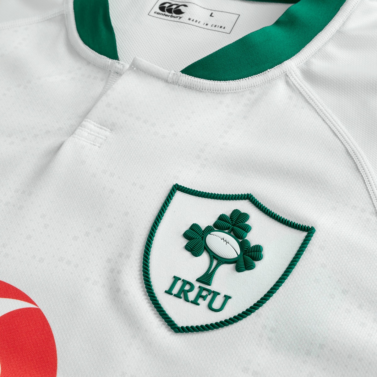 Close-up of the Ireland 25/26 Alternate Pro Jersey by Canterbury, a white rugby jersey with the IRFU crest (green shamrock and rugby ball), green collar trim, and visible Canterbury Vapodri label.