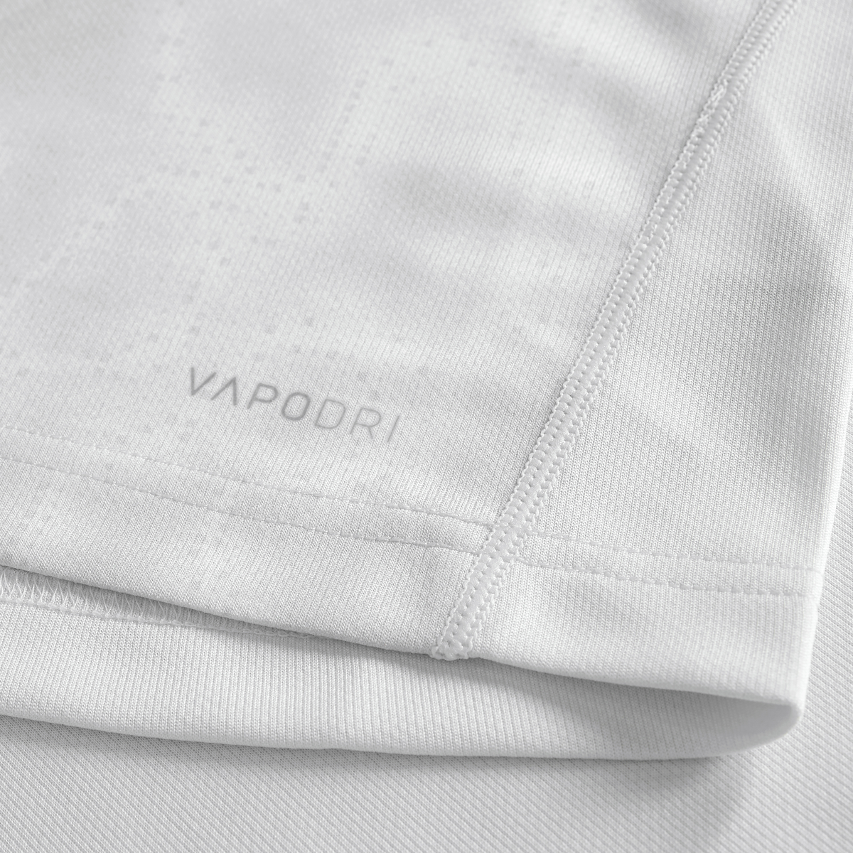 Close-up of the Youth Ireland 25/26 Alternate Pro Jersey by Canterbury in light grey, showing &quot;VAPODRI&quot; near the hem, detailed stitching, and textured fabric—an ideal pick for young rugby fans.