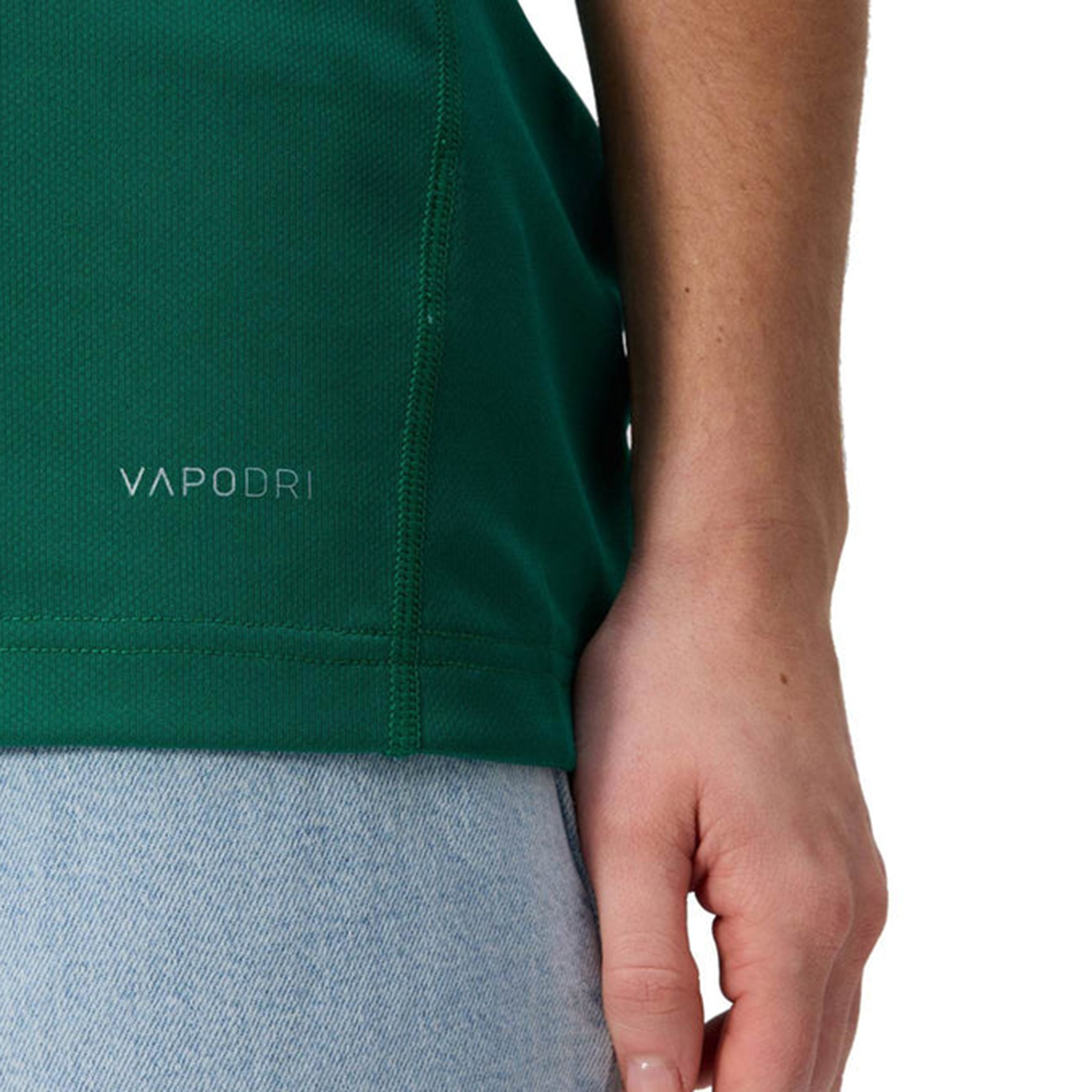 Close-up of a person wearing the Canterbury Women&#39;s Ireland WRWC25 Replica Home Jersey with light blue jeans, hand resting at their side.