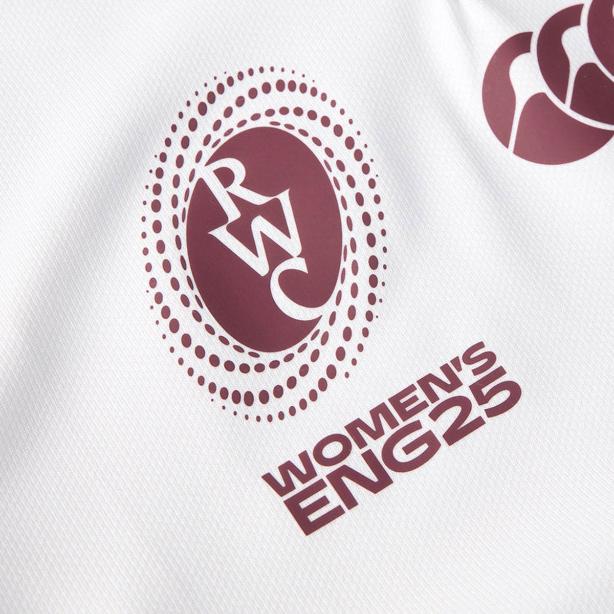 Close-up of a white Canterbury Women&#39;s Ireland WRWC25 Replica Alternate Jersey showing the RWC logo and &quot;Women&#39;s IRE25&quot; in maroon lettering.