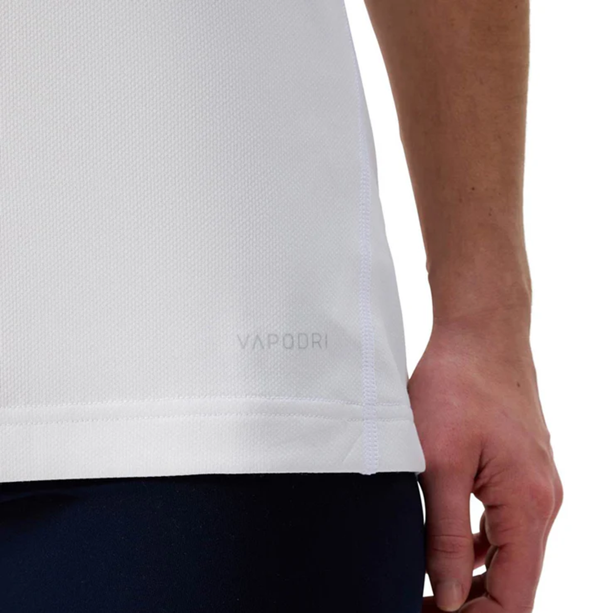 A close-up of a person’s hand resting by their side, wearing the Canterbury Women&#39;s Ireland WRWC25 Replica Alternate Jersey and dark pants.