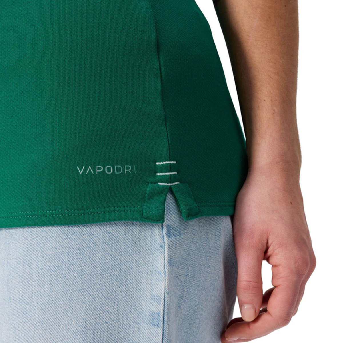 A woman wearing the Women&#39;s Ireland WRWC25 Classic Jersey by Canterbury, featuring &quot;VAPODRI&quot; branding, and light blue jeans is shown from the side with her hand by her hip.