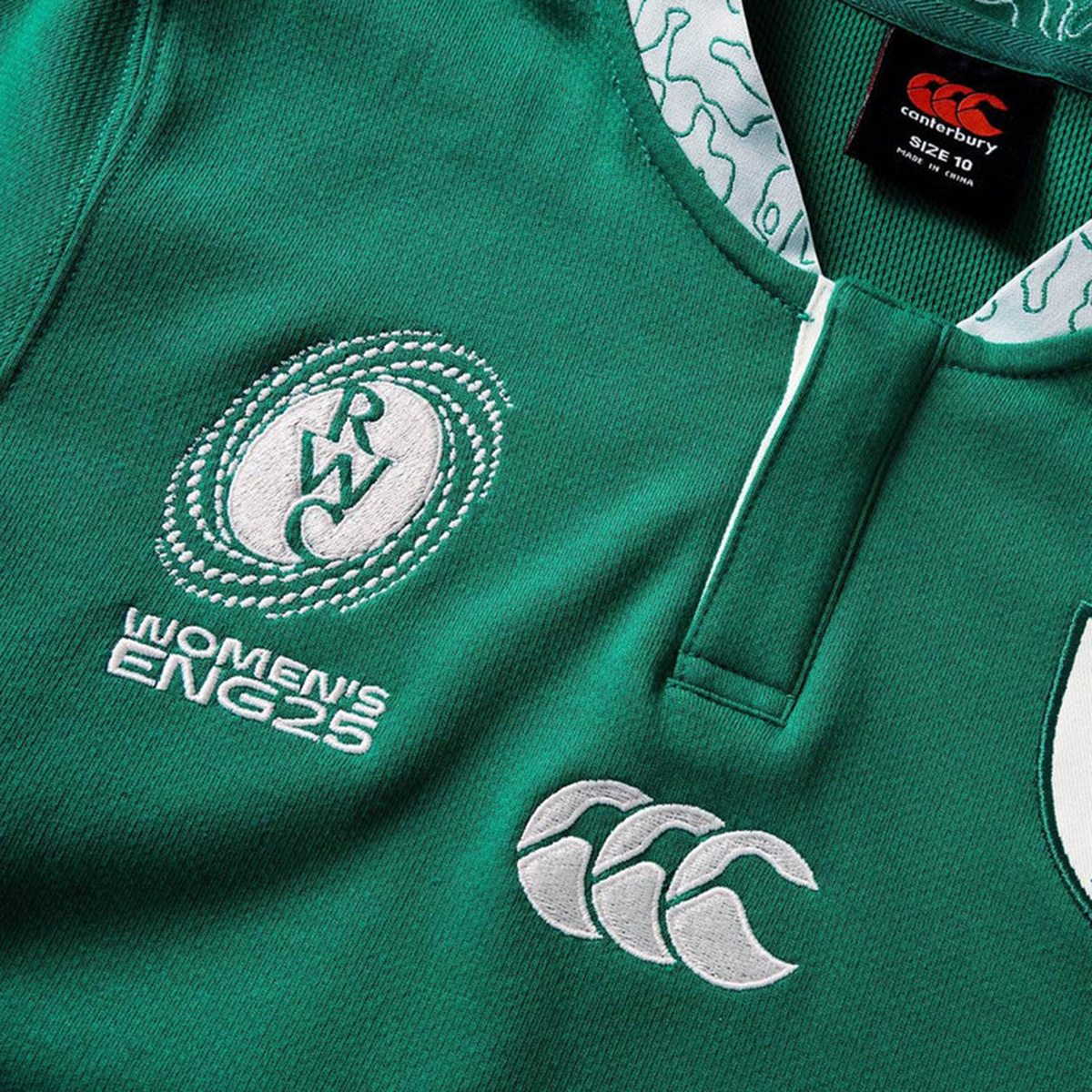 Close-up of the Women&#39;s Ireland WRWC25 Classic Jersey by Canterbury, featuring &quot;RWC Women&#39;s ENG25,&quot; the Canterbury logo, and a detailed collar with white patterns—perfect for fans of Ireland&#39;s women&#39;s rugby.