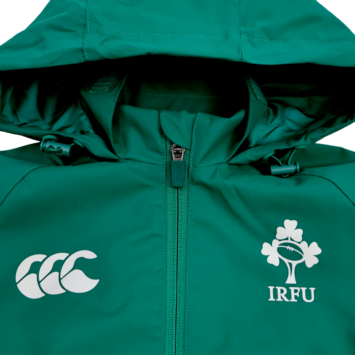 The Youth Ireland 25/26 Anthem Track Jacket by Canterbury features a green hood, zip front, and displays the iconic Canterbury logo alongside the Ireland rugby emblem.