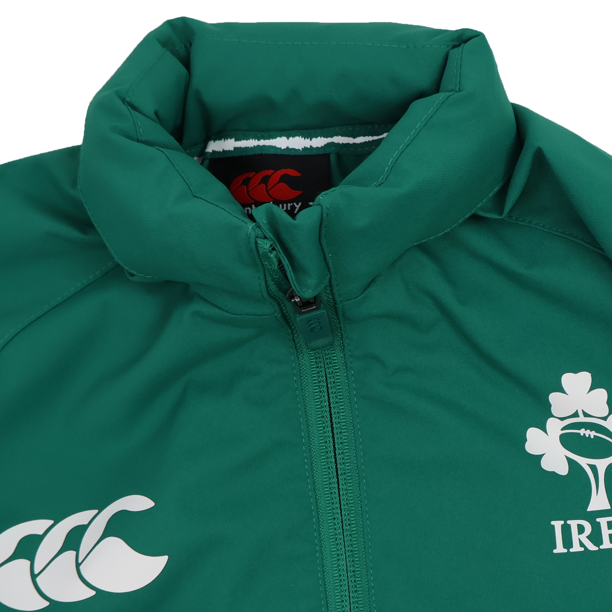 Close-up of the Youth Ireland 25/26 Anthem Track Jacket by Canterbury, featuring a green design with zip closure, Canterbury logo, and shamrock emblem. Ideal for young rugby fans and players supporting Ireland.