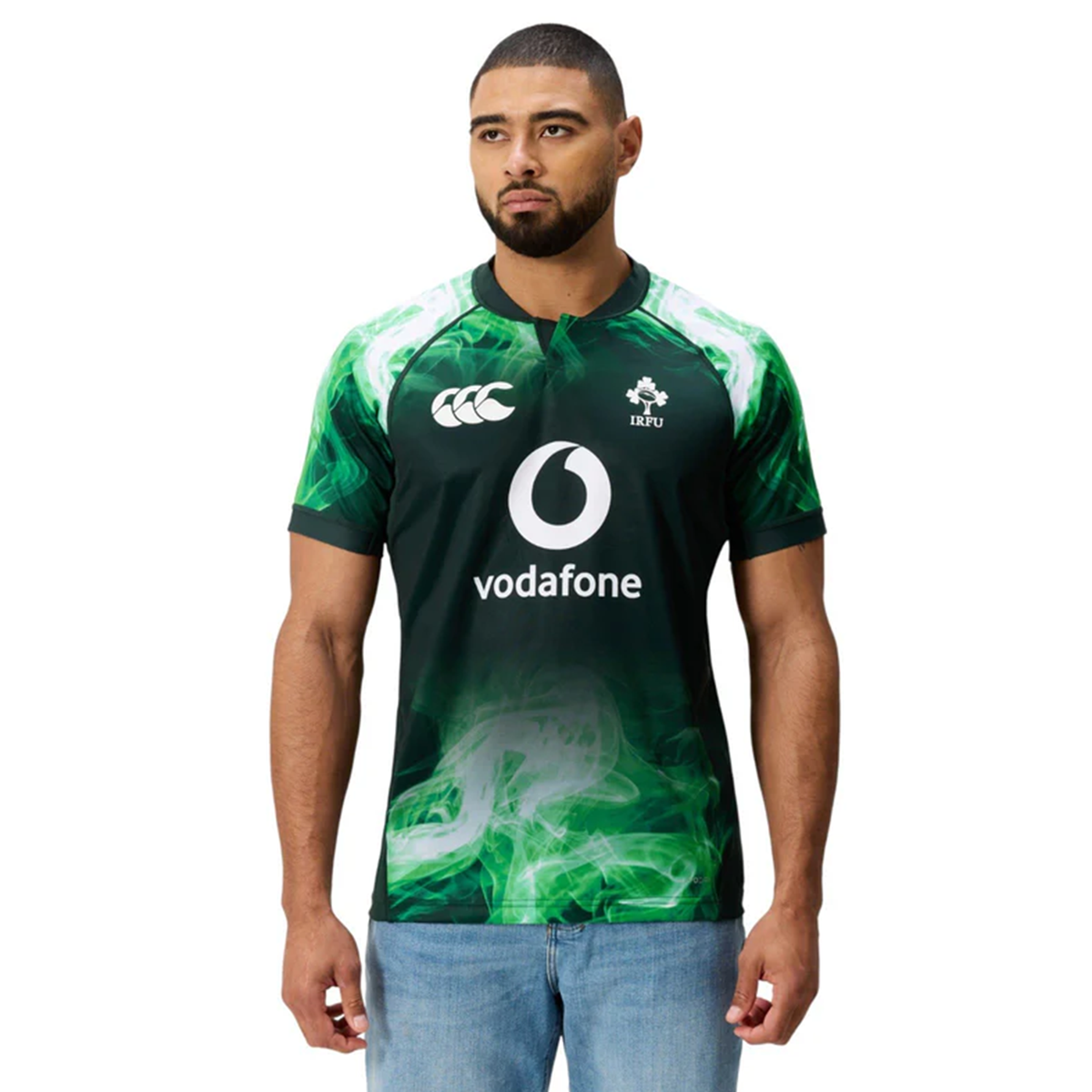 A man wearing the Limited Edition Ireland "Chicago" Pro Pre-Game Jersey by Canterbury, in green and black with sponsor and team logos, stands with arms relaxed by his sides against a plain white background.