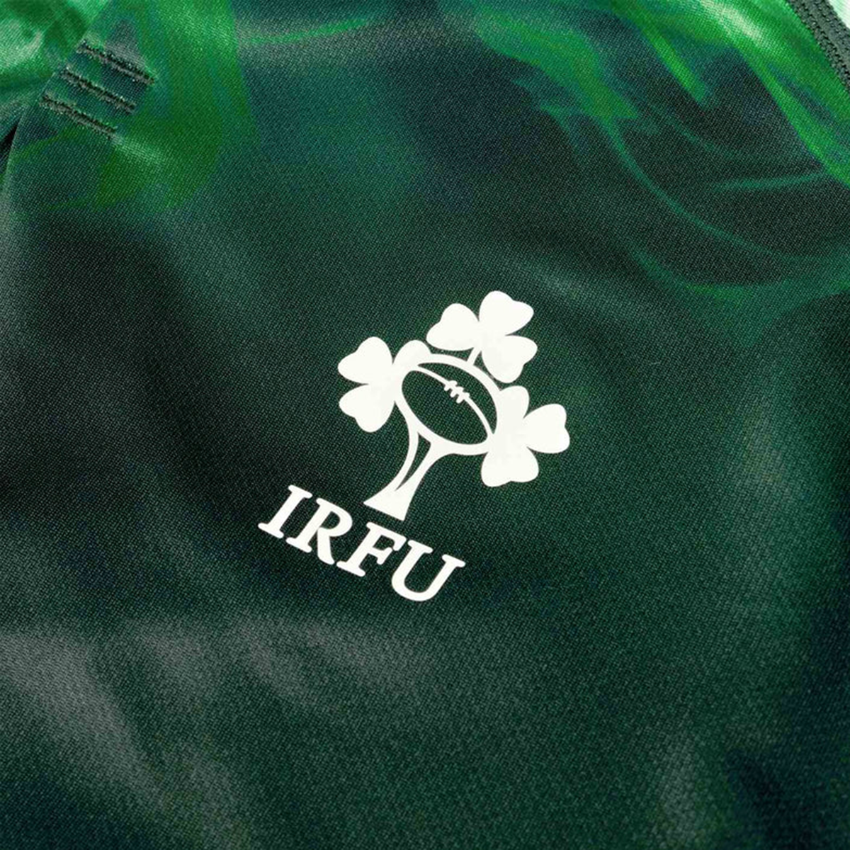 Close-up of the Irish Rugby Football Union (IRFU) logo with rugby ball and shamrock on the Limited Edition Ireland "Chicago" Pro Pre-Game Jersey by Canterbury, featuring advanced VapoDri tech on dark green fabric.