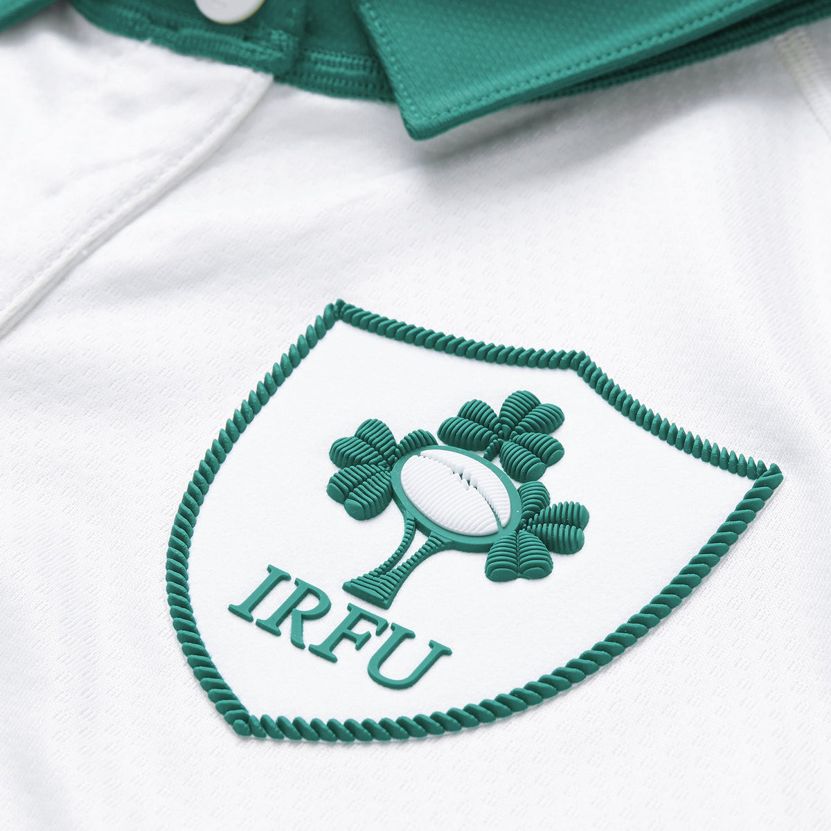 Close-up of the Ireland 26 Alternate Test Jersey by Canterbury, featuring the IRFU logo with a shamrock and rugby ball, displayed on a white background with a green collar.