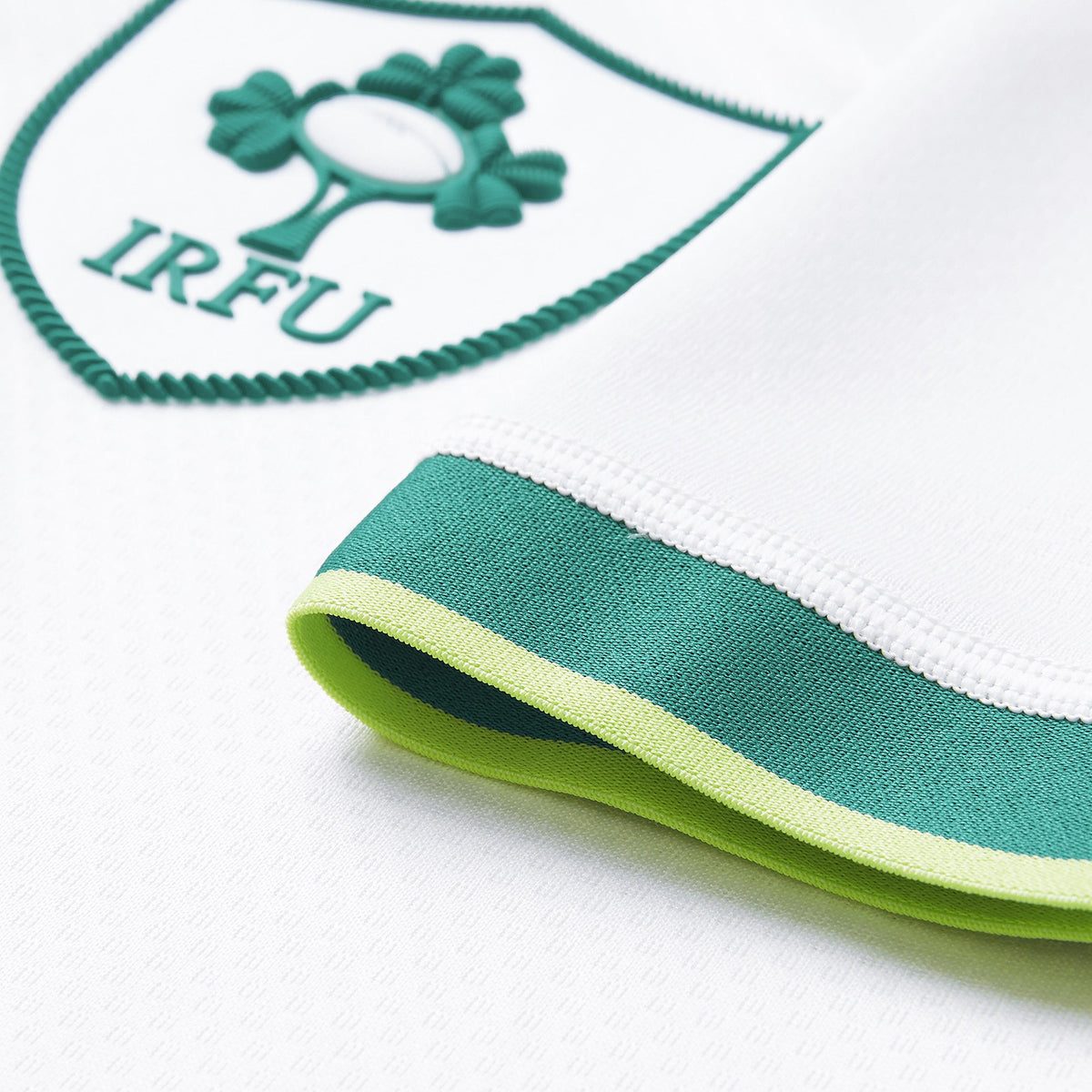 Close-up of the Ireland 26 Alternate Test Jersey by Canterbury, a white Performance Rugby Jersey featuring a green IRFU badge and a green and yellow trim on the sleeve.