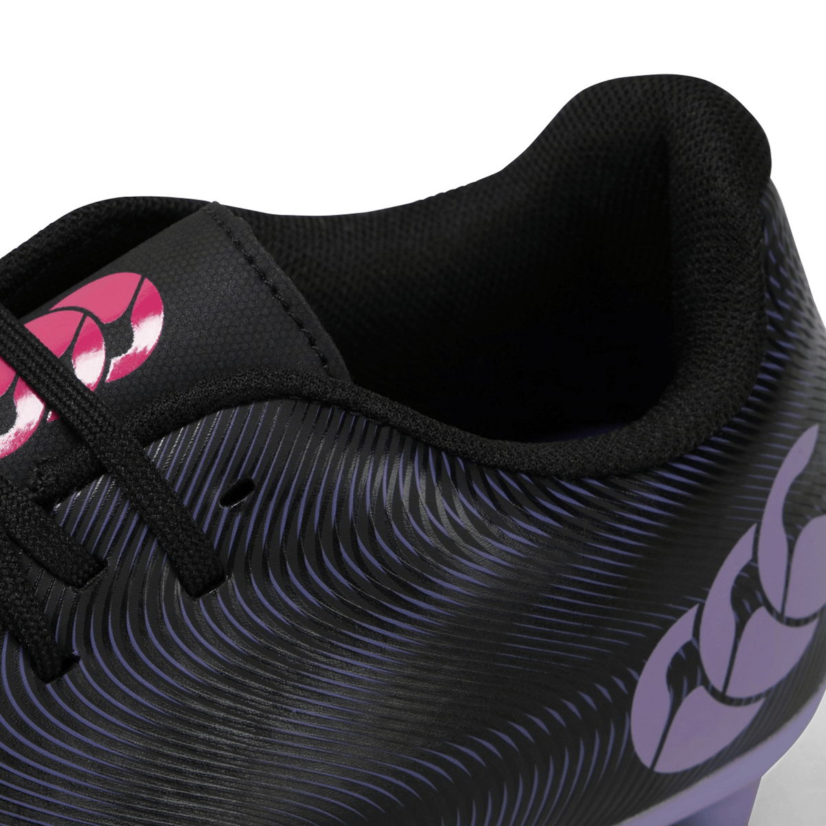 Close-up view of a Canterbury Phoenix Genesis Team FG - Black/Verbena sports shoe with a patterned Vaposkin design and a pink logo.