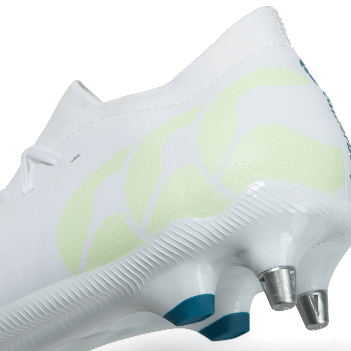 Close-up of a white Canterbury Speed Infinite Pro SG soccer boot with green accents and soft-ground metal studs.