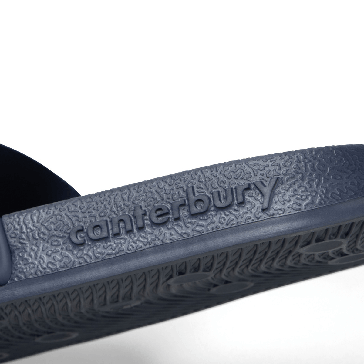Close-up view of the text “Canterbury” embossed on the textured sole of the navy Canterbury Wide Fit Slide, designed for ultimate comfort.