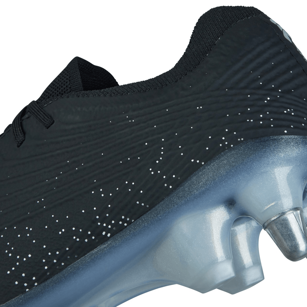 Close-up of the Canterbury Stampede Groundbreak Elite SG - Black/Silver Metallic athletic shoe featuring a black textured surface with small white speckles and a translucent cleat on a grayish-blue sole equipped with the M5 Stud Kit.