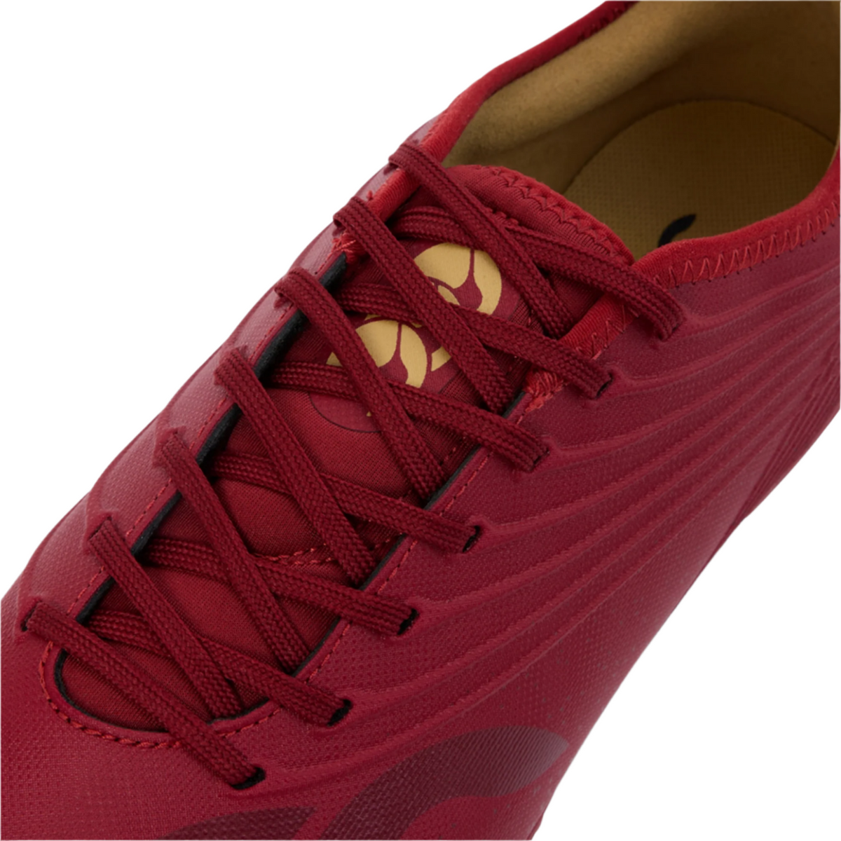 Close-up of the Canterbury Stampede Groundbreak Pro SG - Red Dahlia by Canterbury, featuring red laces, a tan insole, premium soft ground rugby boot style, detailed stitching, and curved patterns.