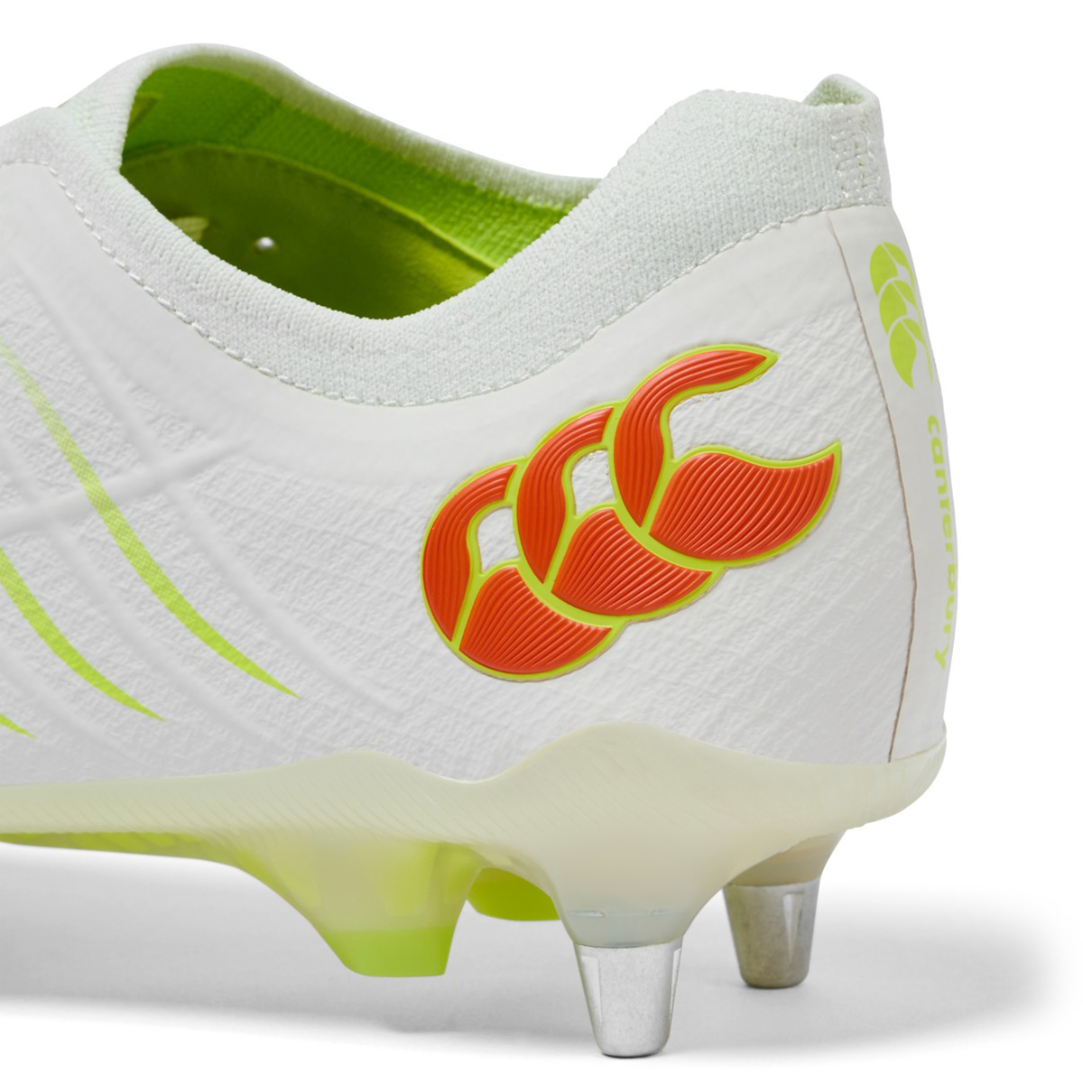 Close-up of the heel and side of a Canterbury Phoenix 2.0 Elite SG boot in Snow White/Tangerine Tango with neon green accents, red logo, and metal studs, featuring the Canterbury brand name.