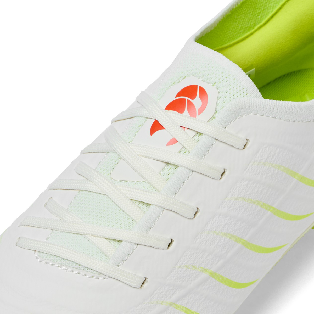 Close-up of the Canterbury Phoenix 2.0 Elite SG in Snow White/Tangerine Tango—a soft ground rugby boot combining white laces, light green lining, yellow accents, and a red tongue logo for athletes who value style and performance.