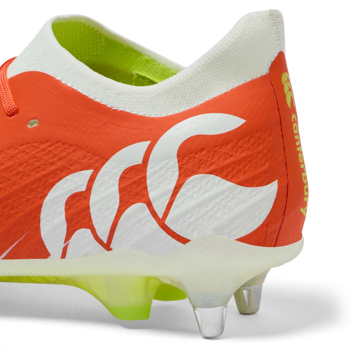 Close-up of the Canterbury Speed Falcon Elite SG rugby boot in Tangerine Tango/Snow White, featuring metal studs, a white logo, and yellow "Canterbury" branding on the heel.