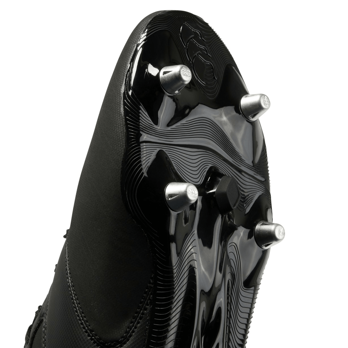 A close-up view of the sole of a black and white Canterbury Phoenix Raze SG Boot featuring high-traction metal studs.
