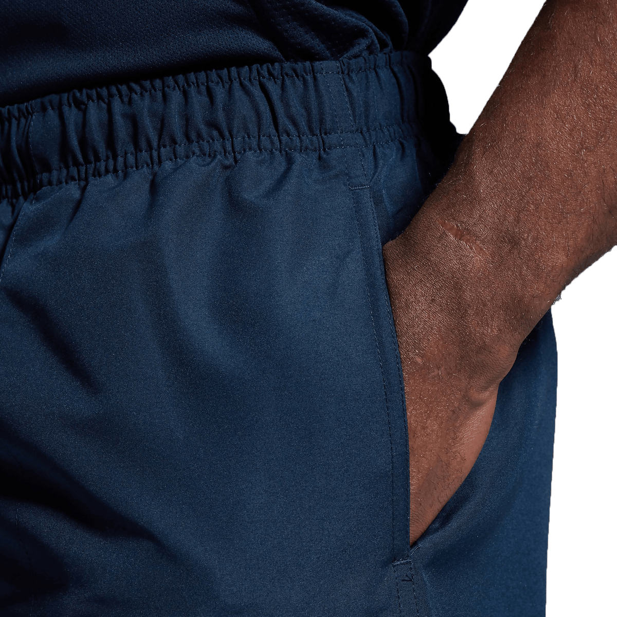 Close-up of a person’s hand in the pocket of Canterbury Tactic Short from the Bundle Canterbury dark blue 3-Pack against a plain background.