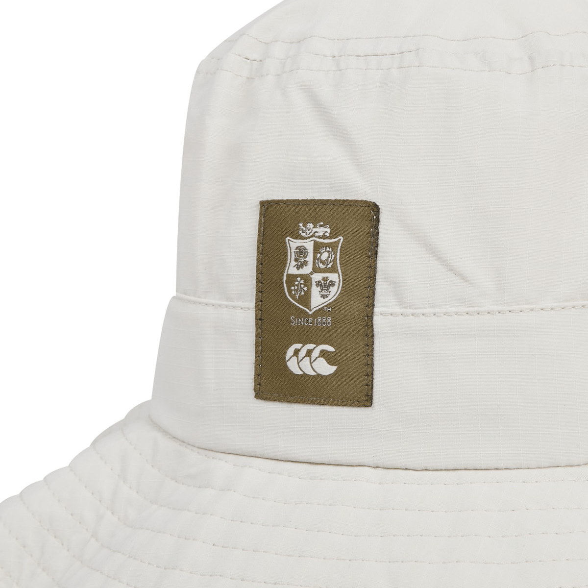 Here's a close-up of the British &amp; Irish Lions 2025 Outback Wide Brim Bucket Hat by Canterbury. Crafted from quick-dry ripstop polyester, it features a distinctive brown patch with a shield design and "Since 1888" beneath which adds a stylish touch for fans seeking both practicality and flair.