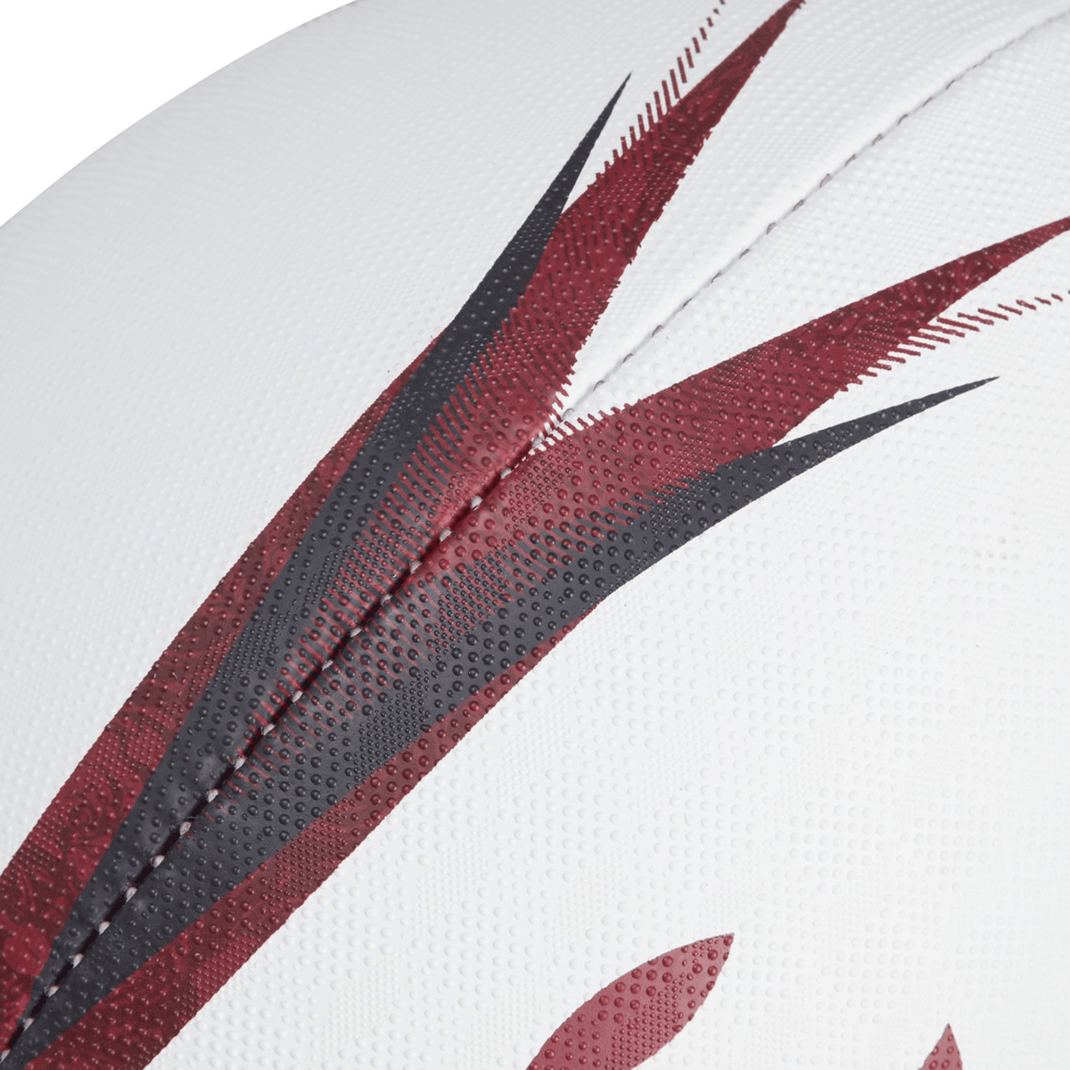 Close-up of the British &amp; Irish Lions 2025 Mentre Sponsor Ball by Canterbury, a white rugby ball made from synthetic rubber, showcasing black and red graphic patterns that echo the bold style of the Lions.